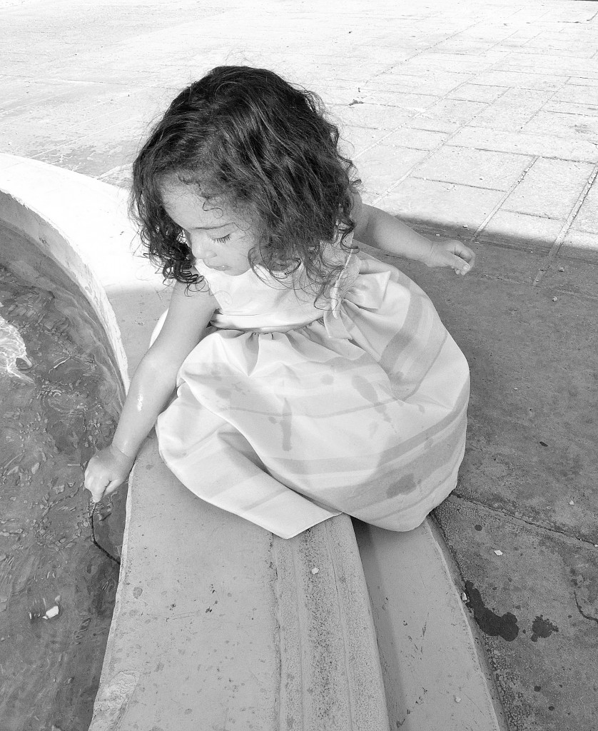 Image of Little girl next toa fountain taken by a photographer